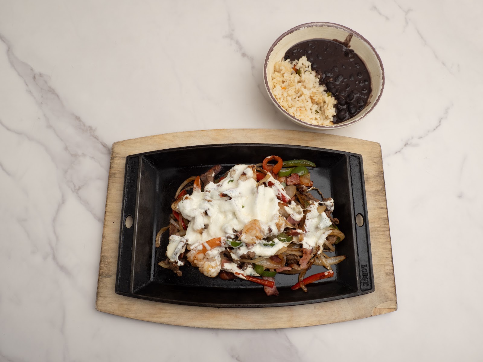 Alambre — sizzling skillet of grilled meat, bacon, peppers and melted cheese